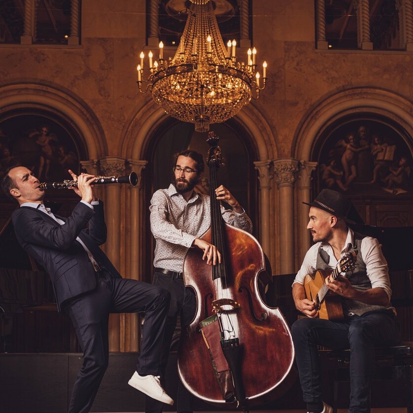 All that Jazz - The Klezmer Brothers | © reithofer-media.com Drei Musiker spielen in einem prunkvollen Raum: Klarinette, Kontrabass und Gitarre. | © reithofer-media.com