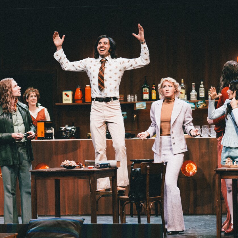 Eine Gruppe von Schauspielern in einem Raum, einer steht auf einem Tisch. | © Lex Karelly