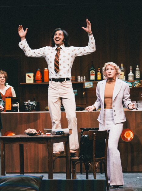 Eine Gruppe von Schauspielern in einem Raum, einer steht auf einem Tisch. | © Lex Karelly