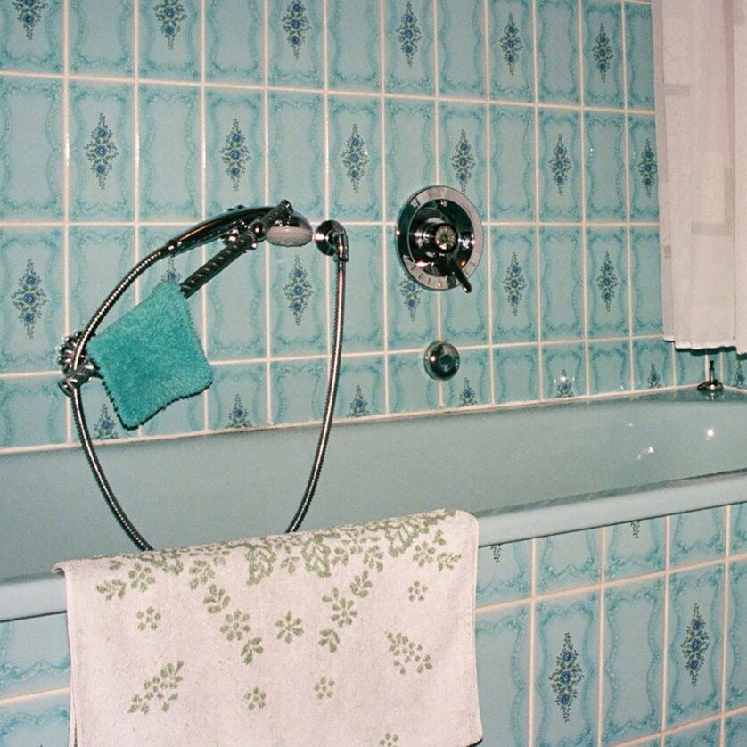 Ansicht einer Badewanne mit blauem Fliesendesign und Handtuch. | © Béla Rittmeyer -  Scroll durch dein Leben!