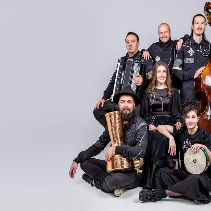 Sechs Musiker posieren mit Instrumenten, darunter ein Kontrabass und Akkordeon. | © Divanhana