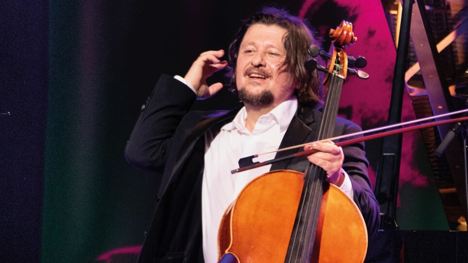 Un violoncellista in un abito nero sorride mentre tiene il suo violoncello. | © Christan Jungwirth
