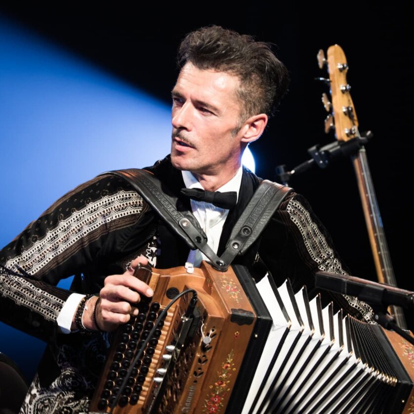 Ein Mann im eleganten Outfit spielt Akkordeon auf der Bühne. | © Ulrike Rauch