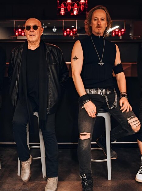 A rock band in modern attire poses together for a photo. | © Lewis Milne