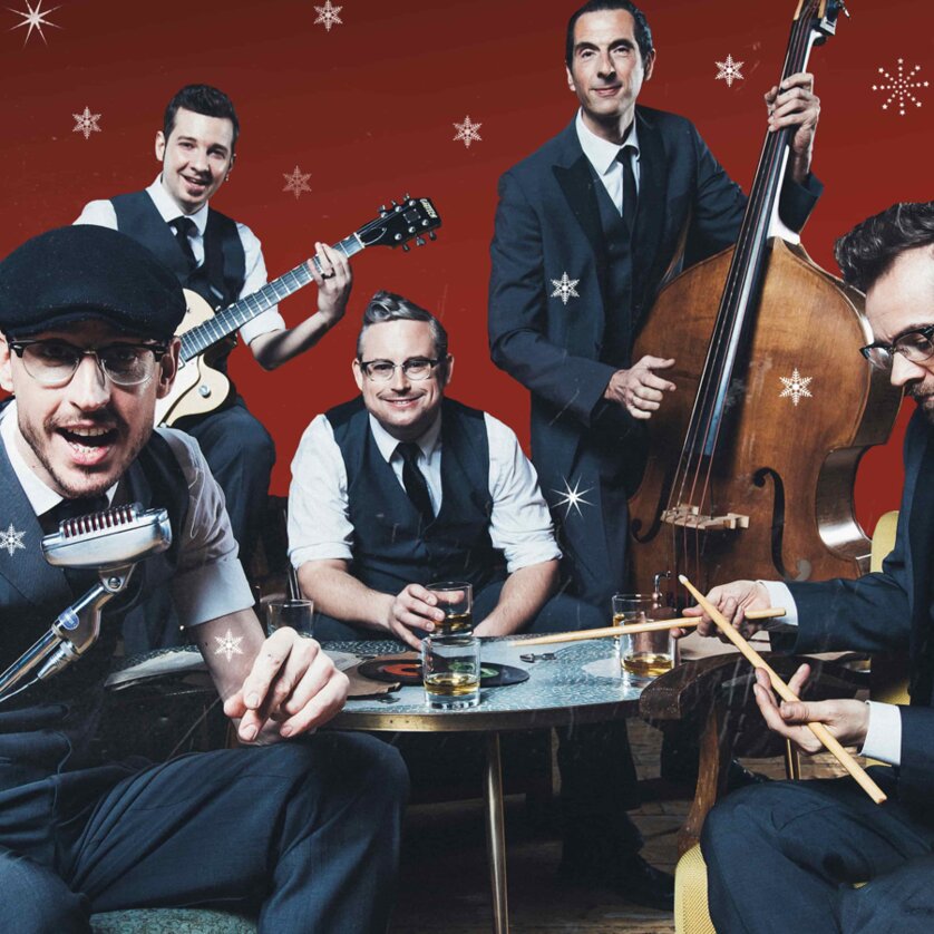 Oldschoolbasterds Vintage Christmas | © Marija Kanizaj Fünfköpfige Vintage-Band in Anzügen mit Instrumenten vor rotem Hintergrund mit Schneeflocken | © Marija Kanizaj