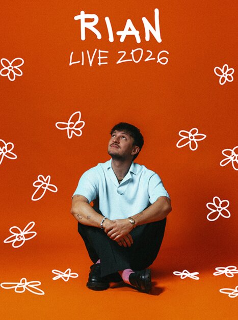 Künstler Rian sitzt vor orangenem Hintergrund, umgeben von gezeichneten Blumen. | © Mario Wallner