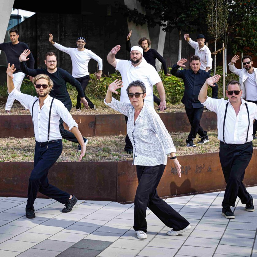 5/8erl in Ehren und Jazzorchester Vorarlberg | © Astrid Knie Eine Gruppe von Musiker:innen in eleganter Kleidung posiert dynamisch. | © Astrid Knie