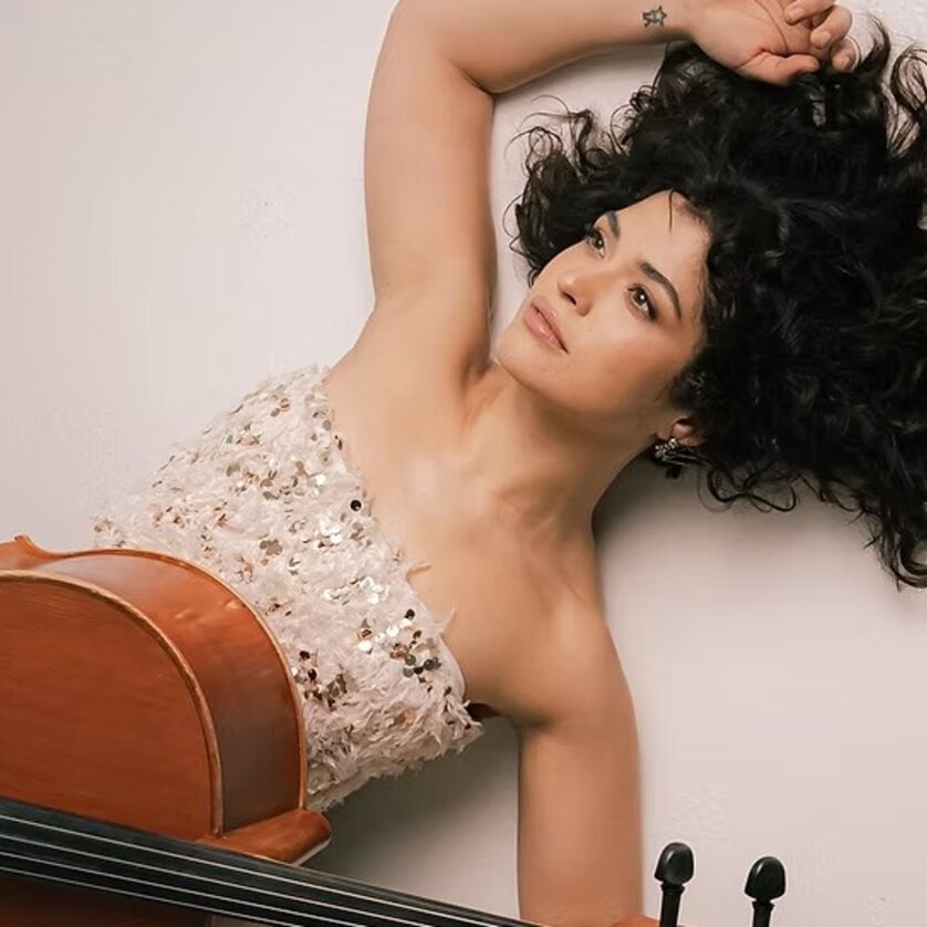 Eine Musikerin mit lockigem Haar posiert mit ihrem Cello. | © ACM Global Music