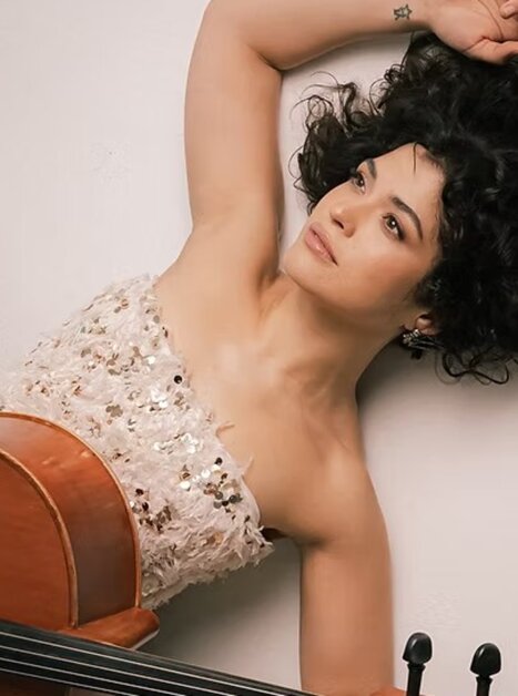 Eine Musikerin mit lockigem Haar posiert mit ihrem Cello. | © ACM Global Music