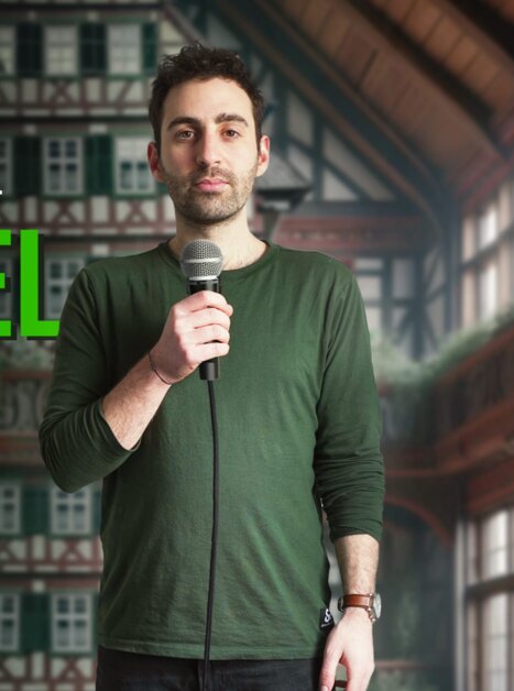 Fabi Rommel auf einer Stand-up Comedy Bühne mit Mikrofon. | © Fabi Rommel