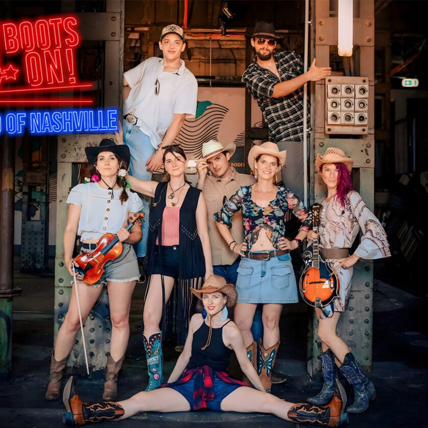 Eine Gruppe von Musikern posiert im Country-Stil mit Instrumenten. | © Boots on
