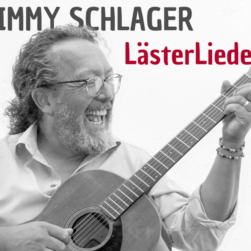 Jimmy Schlager mit Gitarre auf dem Album „LässerLieder“. Ein fröhliches Musikporträt. | © Tibor Kulcsar