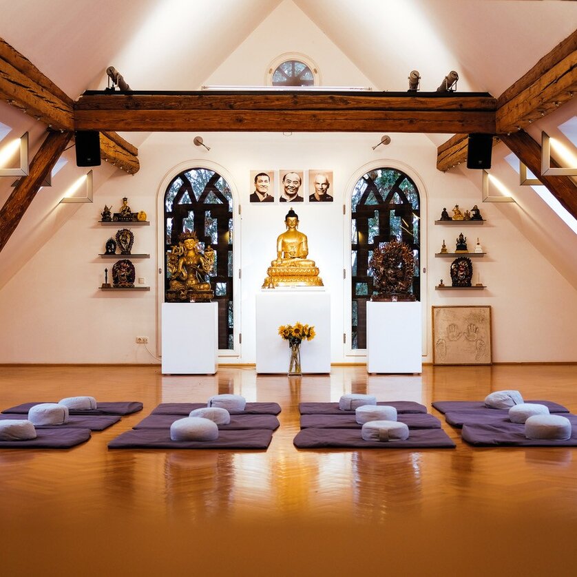 Ein heller Meditationsraum mit Buddha-Statue und Kissen. | © Buddhistisches Diamantwegzentrum Graz