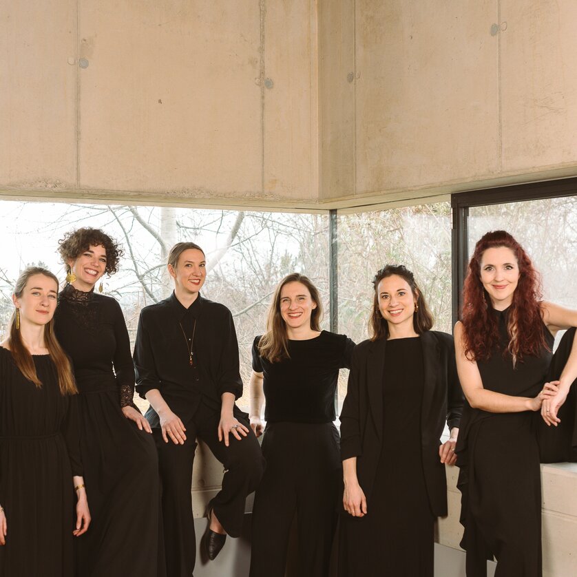The singers of Cantando Admont pose in black clothing in a modern concrete building. | © Theresa Wey