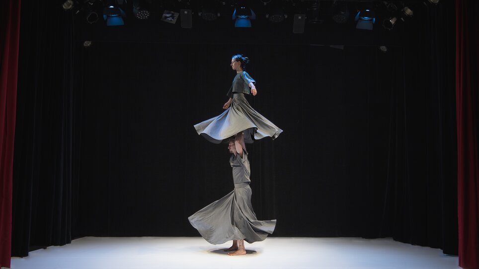 Zwei Tänzerinnen in fließenden Kleidern auf einer Bühne in Bewegung. | © IvanYaher