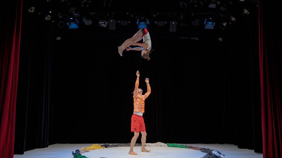 Zwei Akrobaten führen eine beeindruckende Hebefiguren-Performance auf einer Bühne vor. | © IvanYaher