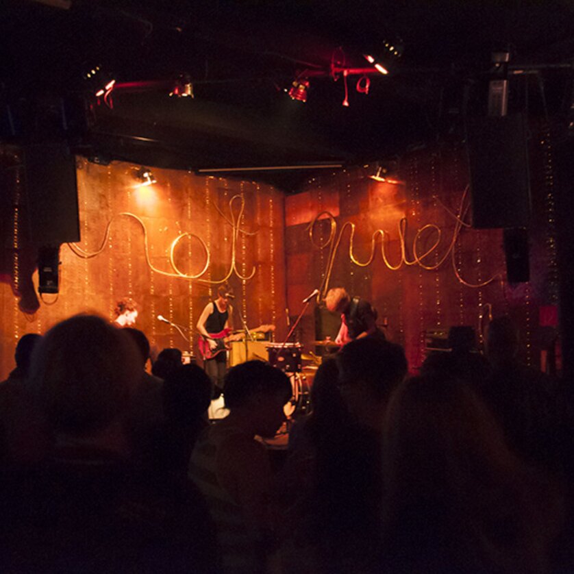 Musiker spielen in einem dunklen Club mit stimmungsvollem Licht. | © Sarah Andree