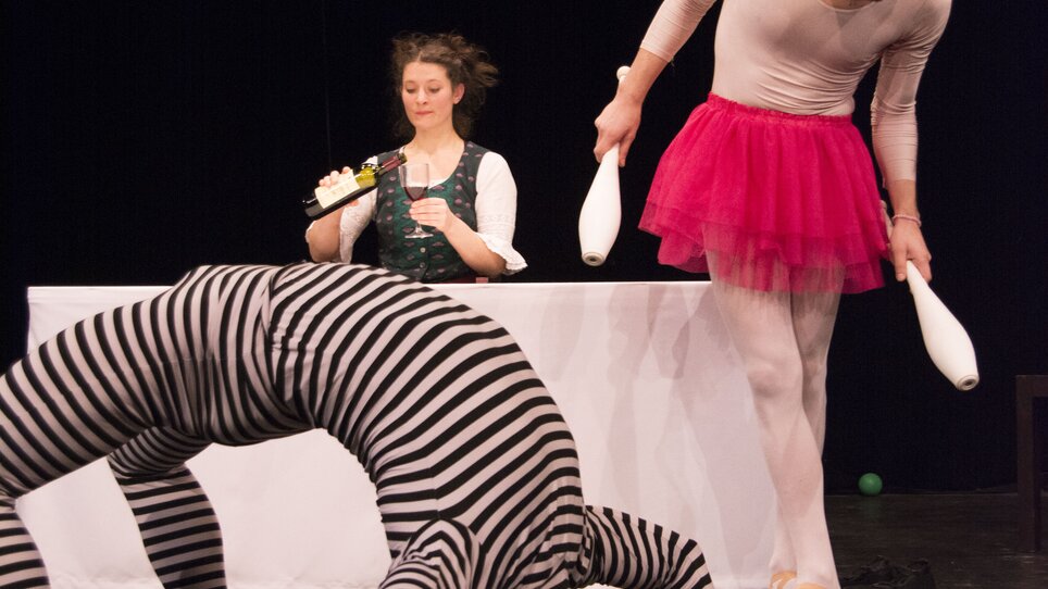 Three individuals in quirky costumes during a stage show. | © Christina Berzaczy