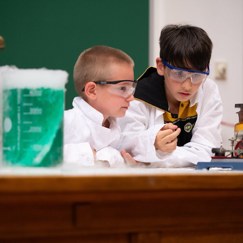 Zwei Kinder in Schutzbrillen führen ein Experiment im Labor durch. | © _Daniel-Auer