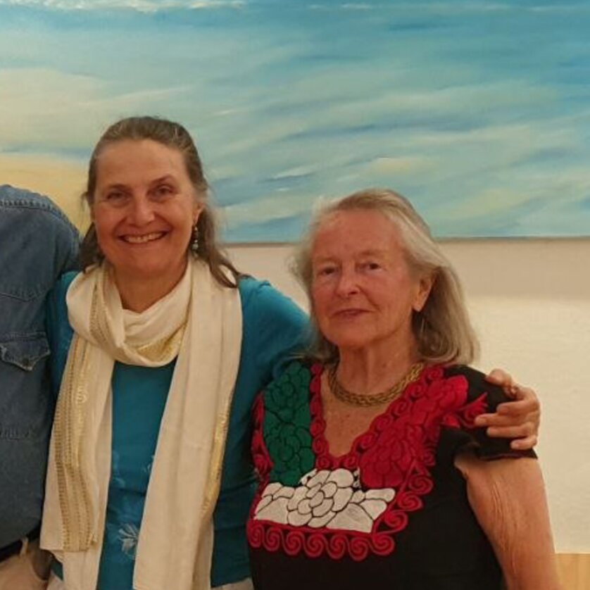 Zwei Frauen stehen vor einem Gemälde mit blauem Hintergrund. | © Renate Urban