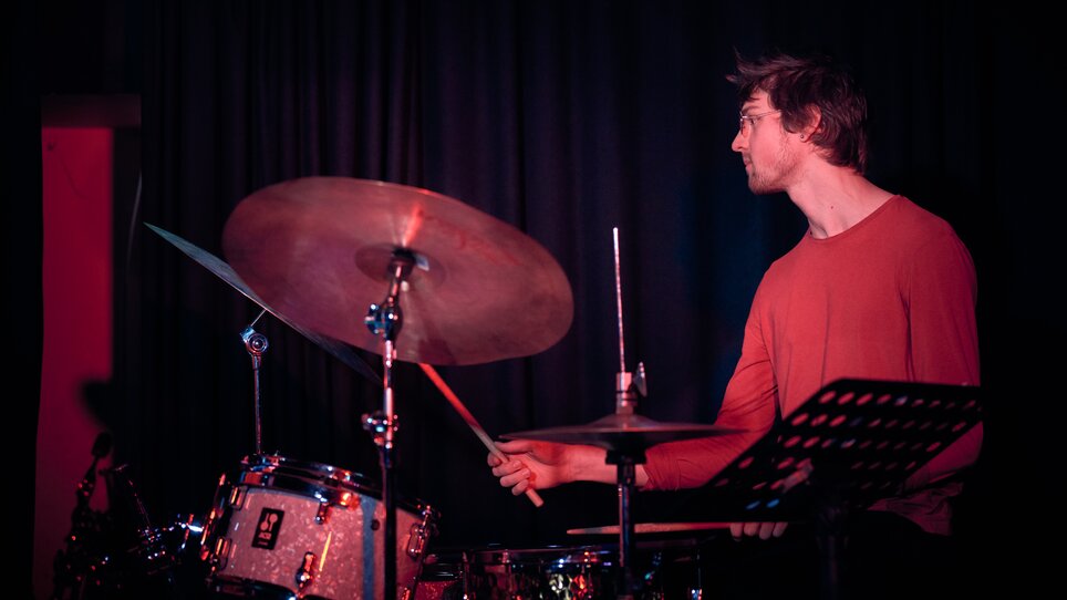 A drummer passionately performing on stage. | © Kuro Simon