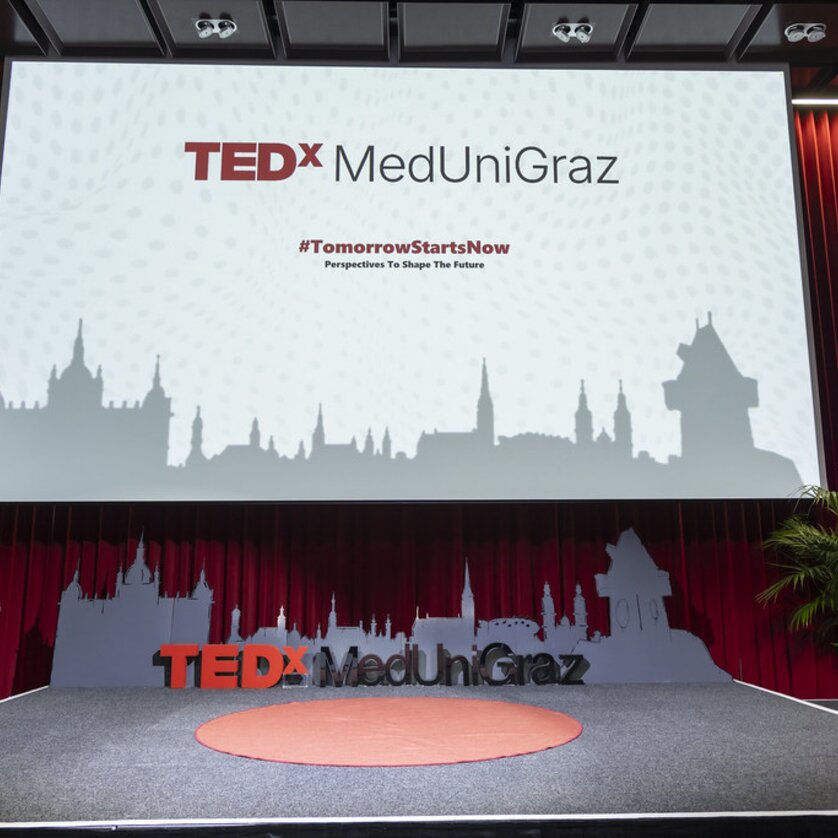 Bühne für TEDx MedUni Graz mit Pflanze und Banner. | © TEDxMedUniGraz