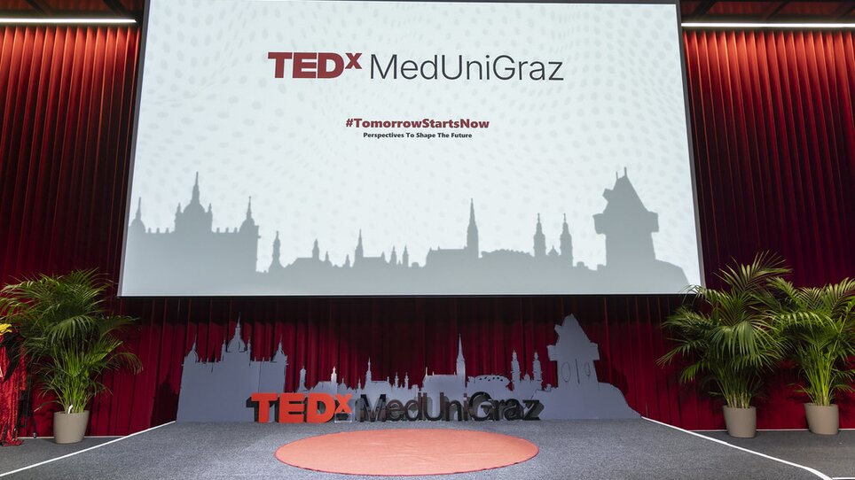 Bühne für TEDx MedUni Graz mit Pflanze und Banner. | © TEDxMedUniGraz