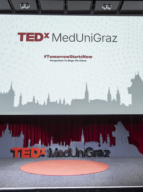 Bühne für TEDx MedUni Graz mit Pflanze und Banner. | © TEDxMedUniGraz