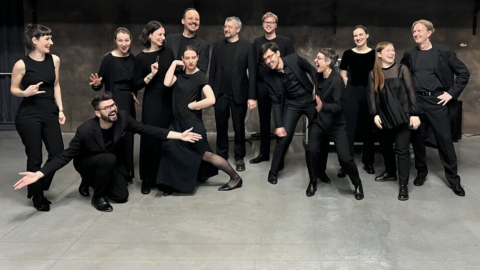 Verschiedene Personen in schwarzer Kleidung, die fröhlich posieren. | © Cantando Admont
