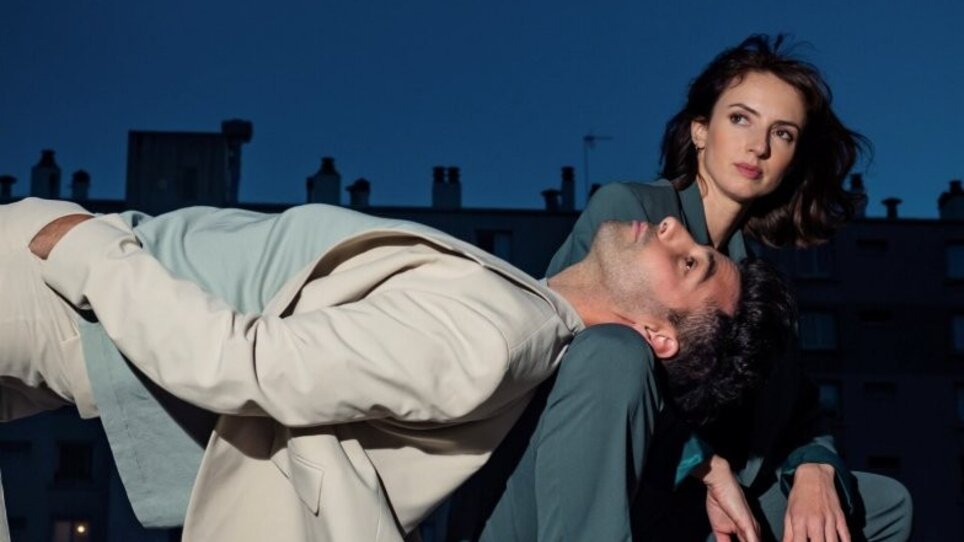 Claire & Antho strike an artistic pose against an urban backdrop at night. | © GLMPOLI