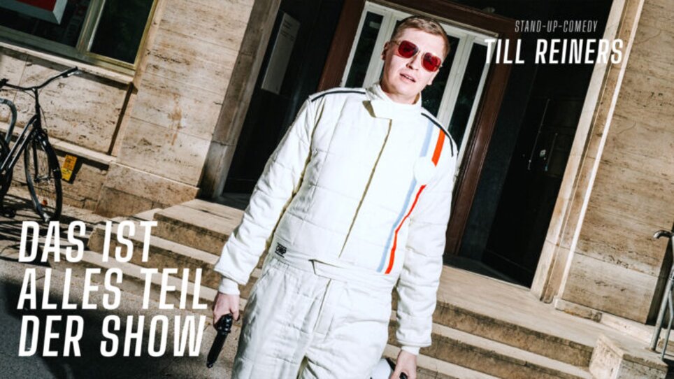 Till Reiners steht in einem weißen Anzug mit Sonnenbrille. | © Hoanzl