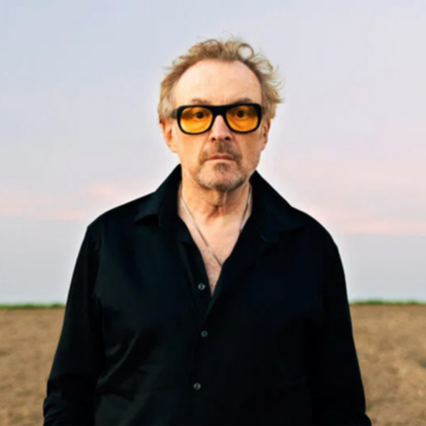 Ein Mann mit Sonnenbrille steht in einem offenen Feld unter einem Himmel. | © Lukas Beck