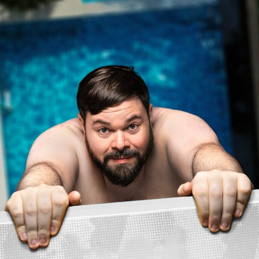 Ein Mann mit Bart hängt an einem Rand, über einem blauen Pool. | © Jan Frankl
