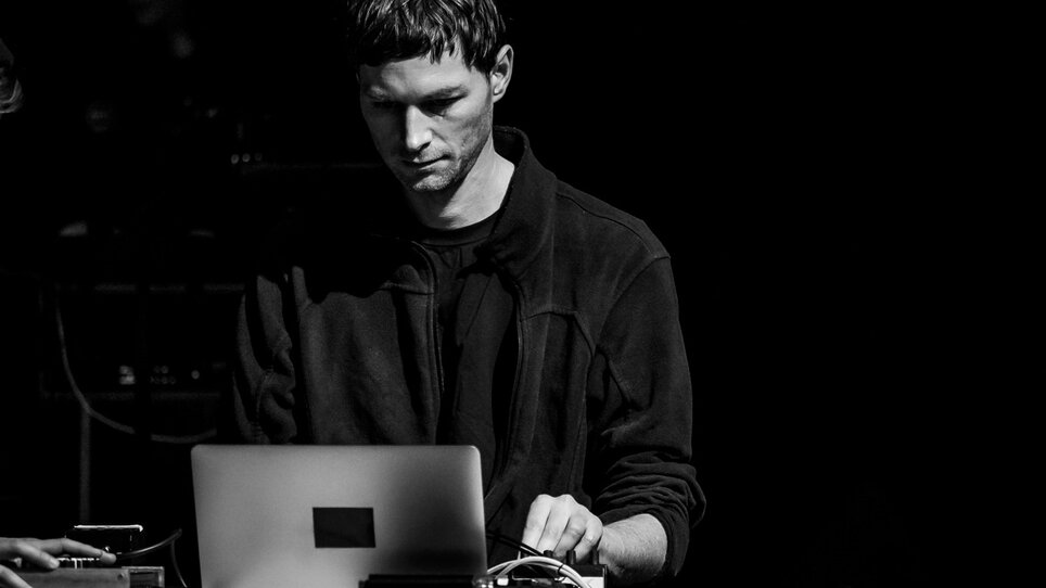 a photograph in black and white shows a young man with a computer and a mixing desk | © Peter Gannushkin