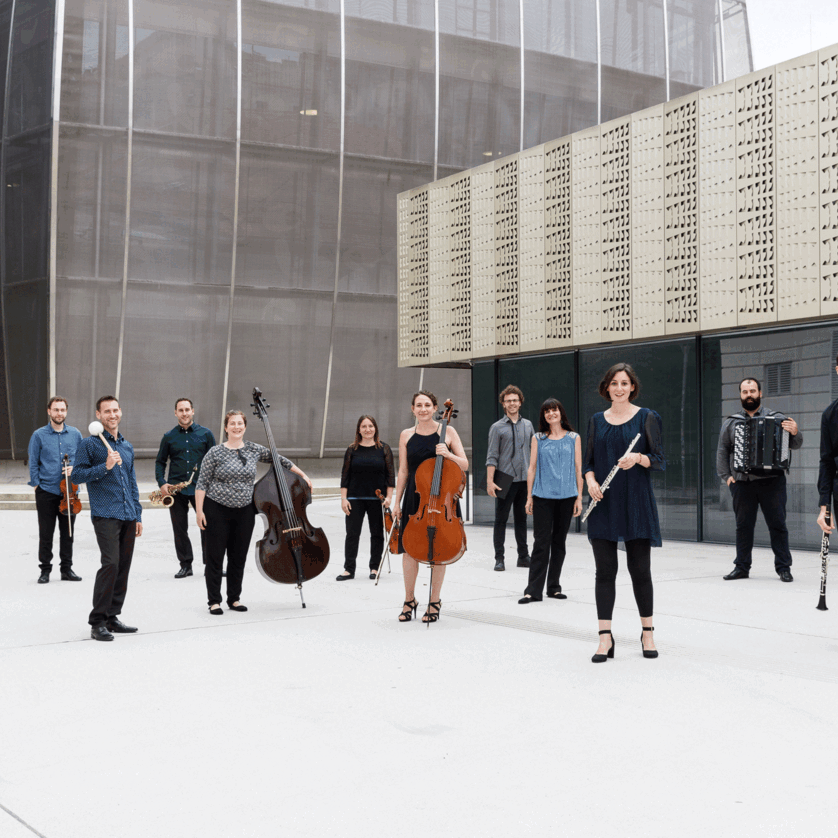 a group of musicians with their instruments stands in front of a modern building | © Maria Frodl