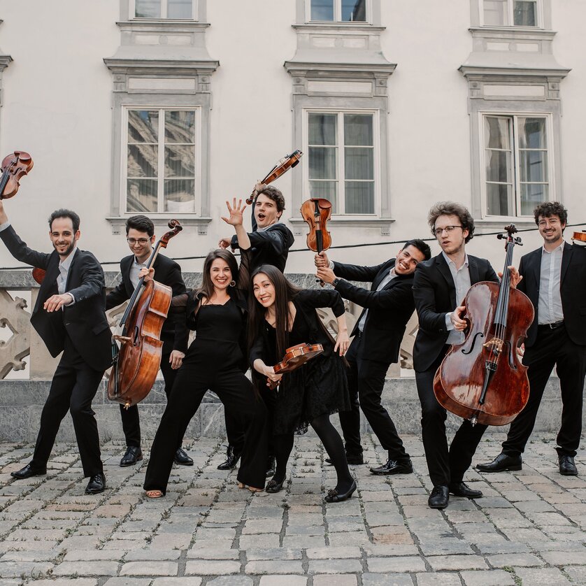 Ein Ensemble in eleganten Outfits posiert lebhaft im Freien. | © Marija Jancic