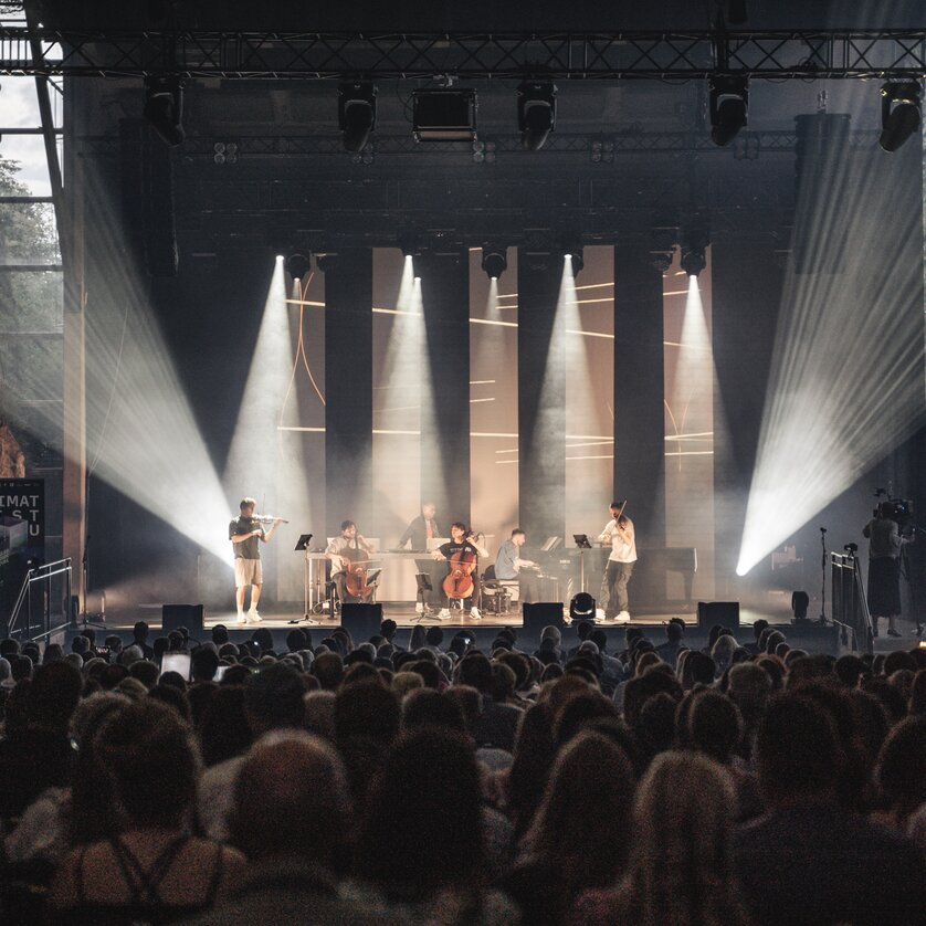 a group of six artists is playing music on a stage | © Reithofer Media