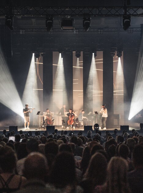 a group of six artists is playing music on a stage | © Reithofer Media