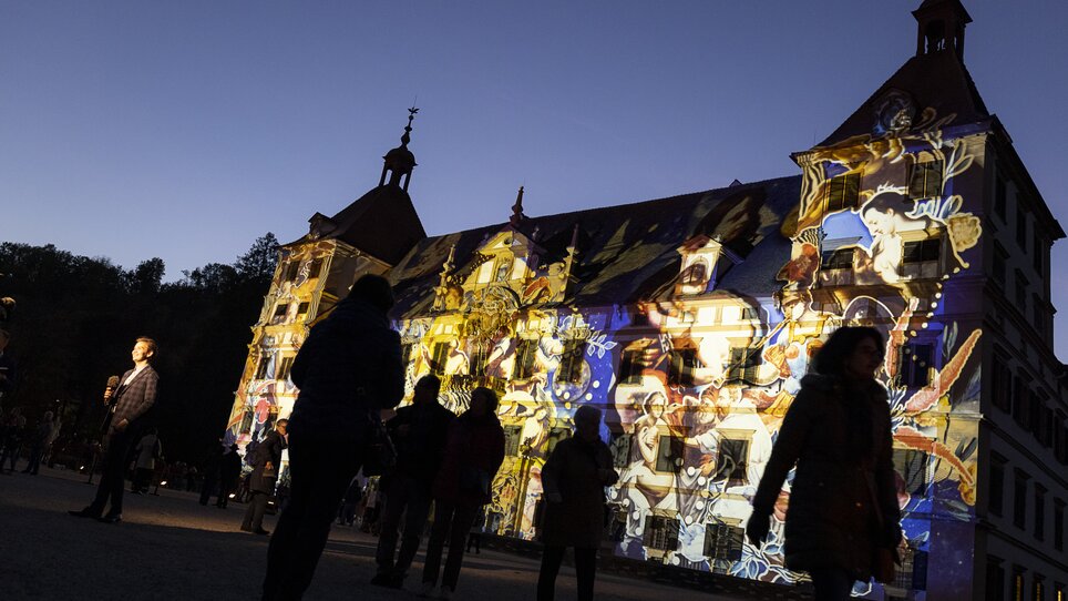 Visitors admire an impressive light projection on an old building. | © Marija Kanizaj