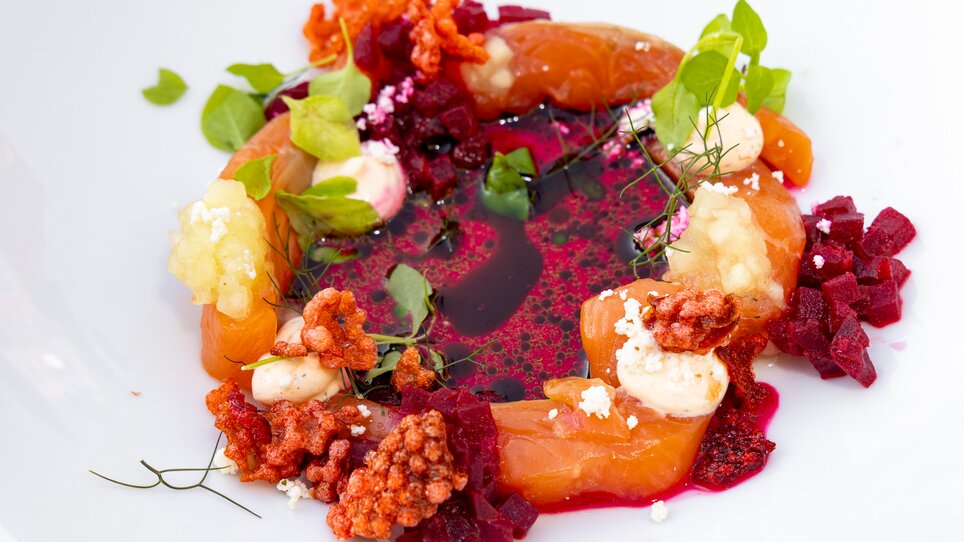 Ein kunstvolles Gericht mit Lachs, Rote Beete und Sauce auf einem weißen Teller. | © Graz Tourismus - Harry Schiffer