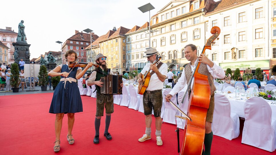 Musiker bei der Langen Tafel in Graz mit festlicher Atmosphäre. | © Graz Tourismus - Harry Schiffer