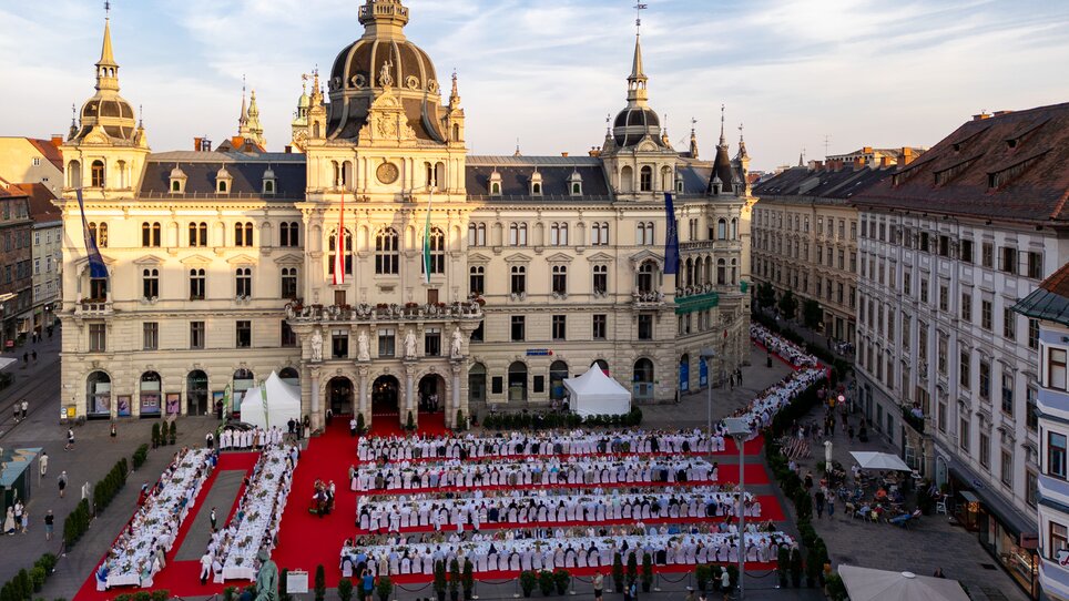 Eine große lange Tafel in Graz vor dem Rathaus bei Sonnenuntergang. | © Graz Tourismus - Harry Schiffer