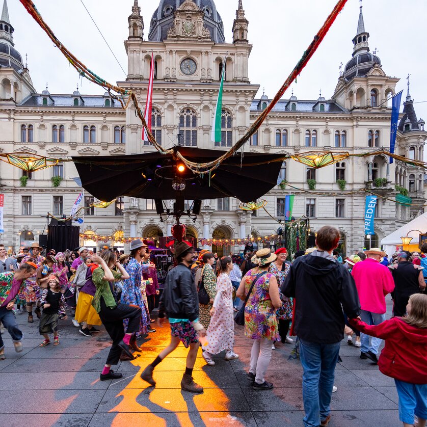 Tanzende Menschen auf dem Hauptplatz von Graz, mit festlicher Stimmung. | © Graz Tourismus - Harry Schiffer