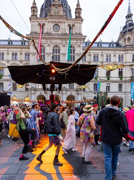 Tanzende Menschen auf dem Hauptplatz von Graz, mit festlicher Stimmung. | © Graz Tourismus - Harry Schiffer