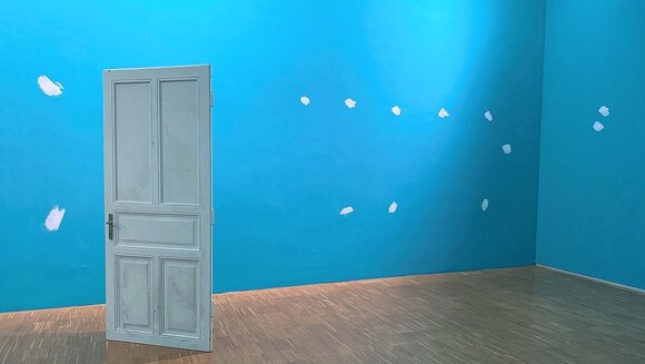 Ein heller, blauer Raum mit einer offenen weißen Tür. | © Kunstvermittlung Neue Galerie Graz - UMJ