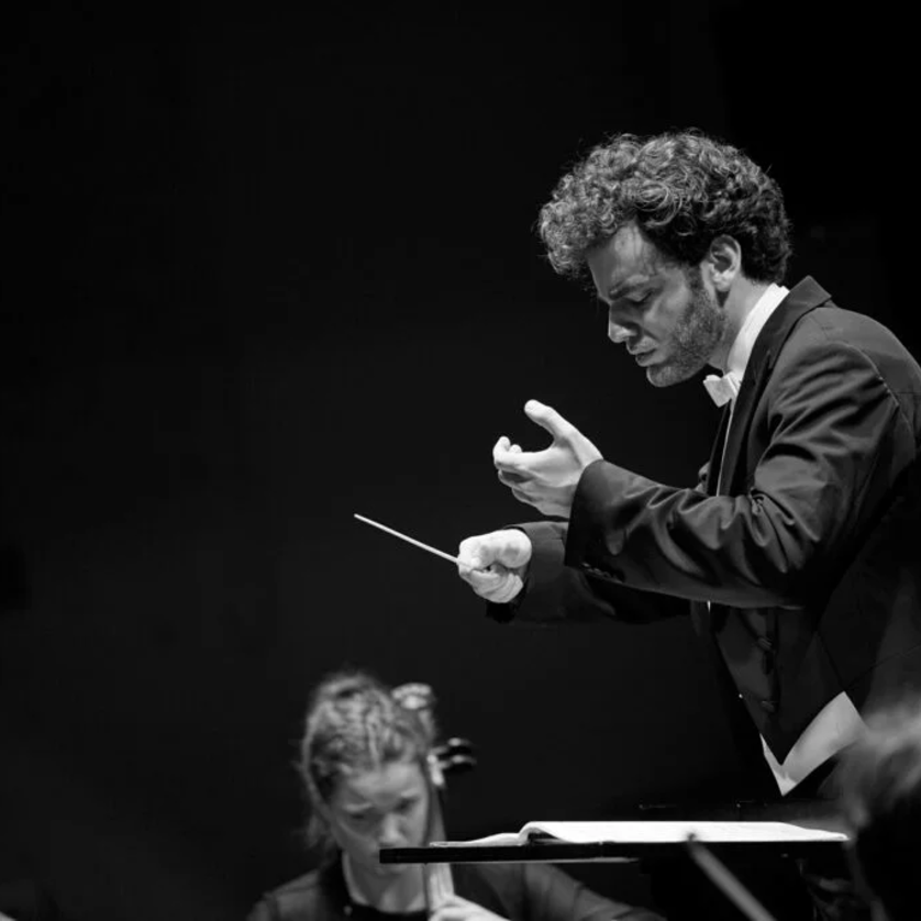 Emmanuel Tjeknavorian | © Oliver Borchert Ein Dirigent leitet ein Orchester mit Leidenschaft in schwarz-weiß. | © Oliver Borchert