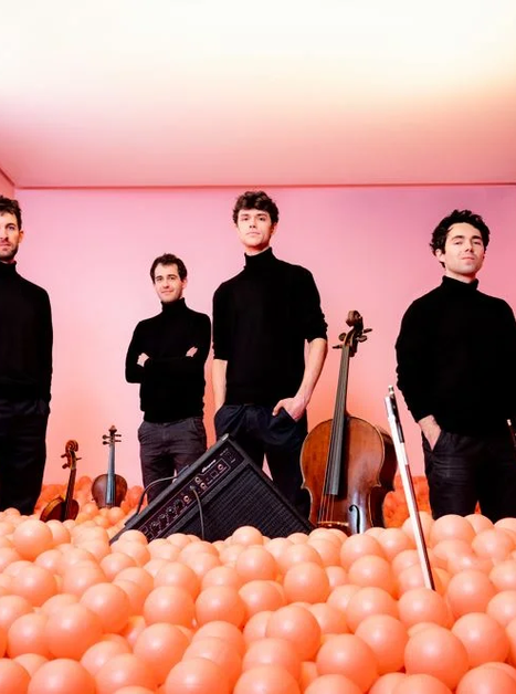 Vier Musiker in schwarzer Kleidung stehen in einer bunten Szenerie aus Kunststoffbällen. | © Harald Hoffmann