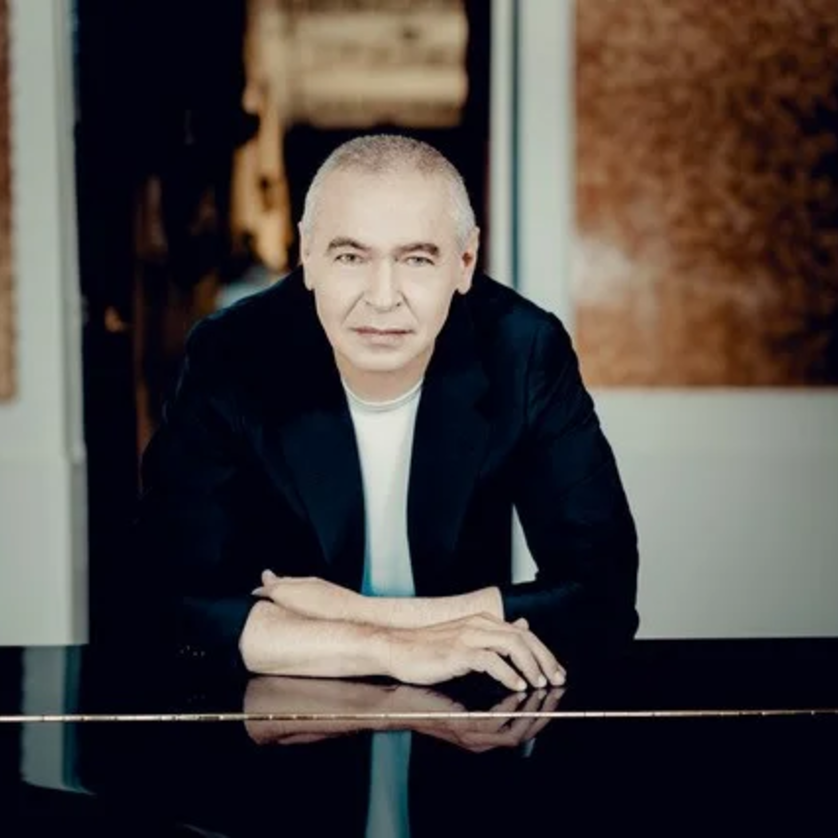 Ivo Pogorelich | © Andrej Grilc Ein Mann in einem schwarzen Blazer lehnt an einem Klavier. | © Andrej Grilc