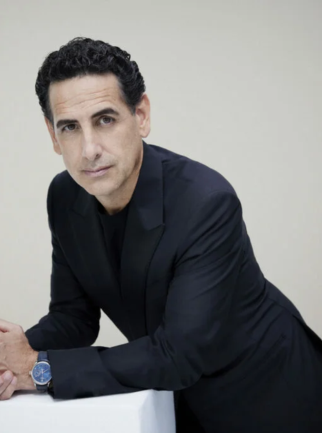 Mann in schwarzem Anzug posiert mit verschränkten Händen. | © Gregor Hohenberg