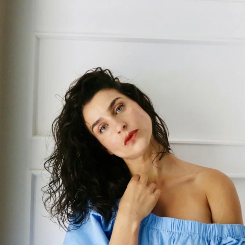 Asmik Grigorian | © Olivia Kahler Porträt einer Frau mit lockigem Haar, die eine blaue Bluse trägt. | © Olivia Kahler